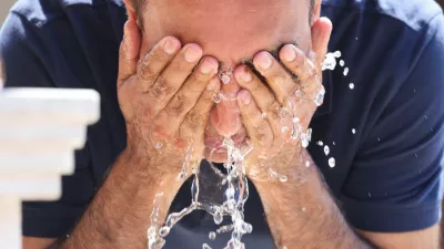 A tourist uses a fountain to cool off amid a heatwave, in Sarajevo, Bosnia and Herzegovina, August 13, 2024. REUTERS/Amel Emric