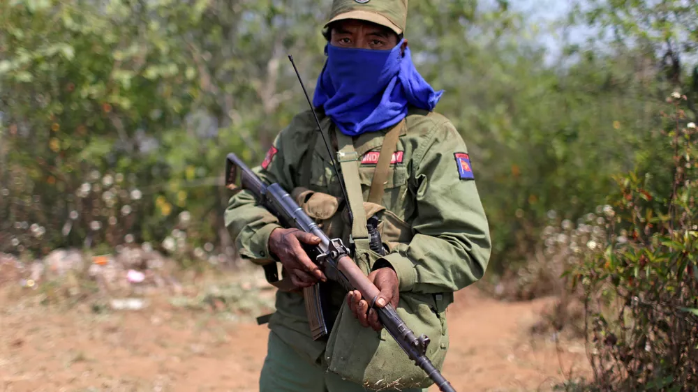 FILE PHOTO: A rebel soldier of the Myanmar National Democratic Alliance Army (MNDAA) holds his rifle as he guards near a military base in Kokang region March 11, 2015. Fighting broke out last month between Myanmar's army and MNDAA, which groups remnants of the Communist Party of Burma, a powerful Chinese-backed guerrilla force that battled Myanmar's government before splintering in 1989. Picture taken March 11, 2015. REUTERS/Stringer (MYANMAR - Tags: MILITARY POLITICS CIVIL UNREST) CHINA OUT. NO COMMERCIAL OR EDITORIAL SALES IN CHINA/File Photo