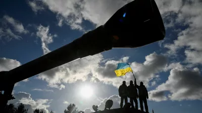 FILE PHOTO: Ukrainian personnel hold a Ukrainian flag as they stand on a Challenger 2 tank during training at Bovington Camp, near Wool in southwestern Britain, February 22, 2023. REUTERS/Toby Melville/File Photo