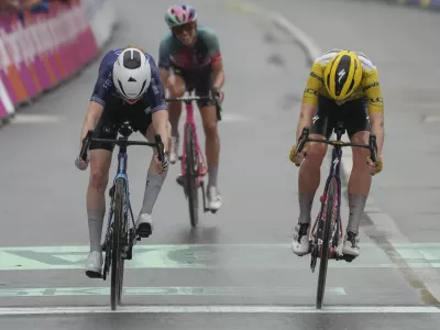 Netherlands Puck Pieterse, left, crosses the finish line ahead of Demi Vollering of The Netherlands, wearing the overall leader's yellow jersey, and Katarzyna Niewiadoma of Poland, rear, to win the fourth stage of the Tour de France Women cycling race with start in Valkenburg, Netherlands, and finish in Liege, Belgium, Wednesday, Aug. 14, 2024. (AP Photo/Peter Dejong)