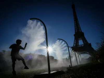 A boy plays under a spray of cooling water on a hot day outside the Eiffel Tower Stadium during the 2024 Olympics in Paris, France, July 28, 2024. REUTERS/Esa Alexander   "OLYMPIC BEHIND THE SCENES" FOR THIS STORY. SEARCH "OLYMPIC SIDELINES" FOR ALL STORIES.