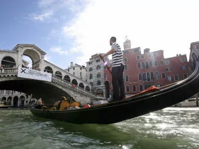 A gondolier rows his gondola next to Rialto Bridge in Venice August 29, 2006. The 63nd Venice Film Festival opens on August 30, bringing 11 days of showbiz parties and glamour to the lagoon city.  REUTERS/Fabrizio Bensch (ITALY)