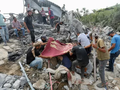 Palestinians stand at the site of an Israeli airstrike on a shelter housing displaced people, amid the conflict between Israel and Hamas, in central Gaza Strip, August 17, 2024. Reuters/Ramadan Abed