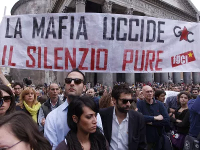 People gather during a demonstration of solidarity in front of Rome's Pantheon for the victims of the explosive device that went off near the "Francesca Morvillo Falcone" high school in Brindisi, Italy, Saturday, May 19, 2012. An explosive device went off outside a high school in southern Italy named after a slain anti-Mafia prosecutor as students arrived for class Saturday, killing one of them and wounding seven others, officials said. The device went off just before 8 a.m. in the Adriatic port town of Brindisi just as students milled outside, chatting and getting ready for class at the vocational institute named after the slain anti-Mafia prosecutor Giovanni Falcone and his wife. The banner reads: "Mafia kills, silence as well (kills)". (AP Photo/Roberto Monaldo, Lapresse) ITALY OUT