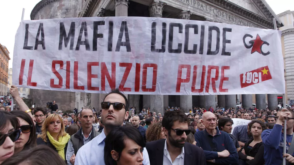 People gather during a demonstration of solidarity in front of Rome's Pantheon for the victims of the explosive device that went off near the "Francesca Morvillo Falcone" high school in Brindisi, Italy, Saturday, May 19, 2012. An explosive device went off outside a high school in southern Italy named after a slain anti-Mafia prosecutor as students arrived for class Saturday, killing one of them and wounding seven others, officials said. The device went off just before 8 a.m. in the Adriatic port town of Brindisi just as students milled outside, chatting and getting ready for class at the vocational institute named after the slain anti-Mafia prosecutor Giovanni Falcone and his wife. The banner reads: "Mafia kills, silence as well (kills)". (AP Photo/Roberto Monaldo, Lapresse) ITALY OUT