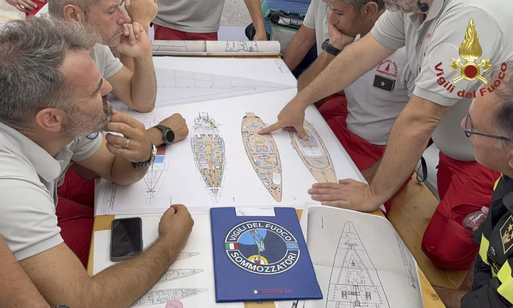 In this picture released by the Italian Firefighters Tuesday, Aug. 20, 2024, Scuba divers study a map of the sailing yacht Bayesian at the Porticello harbor. Rescue teams and divers returned to the site of a storm-sunken superyacht Tuesday to search for six people, including British tech magnate Mike Lynch, who are believed to be still trapped in the hull 50 meters (164-feet) underwater. (Italian Firefighters via AP, HO)