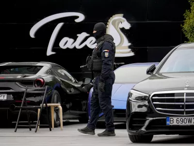 A masked gendarme patrols the courtyard of the residence of social media personality Andrew Tate during an early morning police search raid, on the outskirts of Bucharest, Romania, Wednesday, Aug. 21 2024. (AP Photo/ Vadim Ghirda)