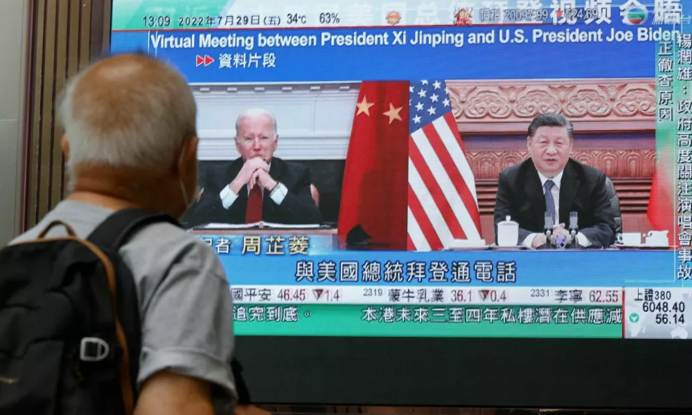 A screen displays images of Chinese President Xi Jinping and U.S. President Joe Biden, while broadcasting news about their recent call at a shopping mall in Hong Kong, China, July 29, 2022. REUTERS/Tyrone Siu