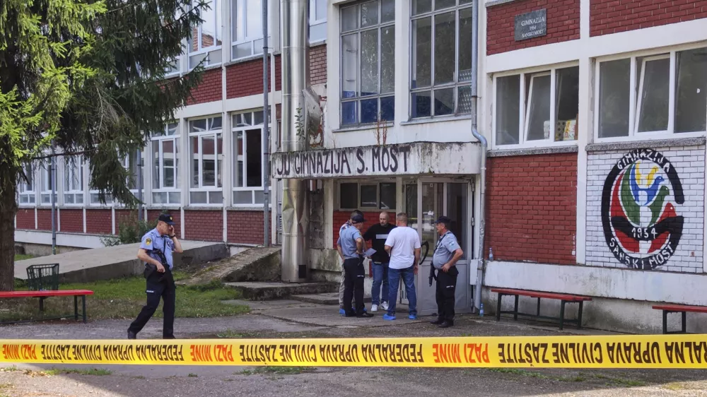 Police officers stand in front of a secondary school building in Sanski Most, northwest of Bosnia's capital, Sarajevo, Wednesday, Aug. 21, 2024, after a school employee shot and killed three people. (AP Photo/Edvin Zulic)