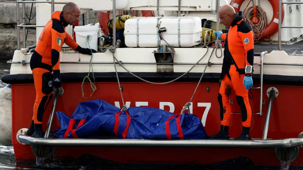 Rescue personnel transport a body bag containing the corpse of British entrepreneur Mike Lynch, who died when a yacht owned by his family sank off the coast of Porticello, near the Sicilian city of Palermo, Italy, August 22, 2024. REUTERS/Guglielmo Mangiapane