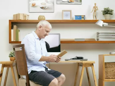 Mature programmer sitting at his working table at home and reading requirement specification on tablet computer / Foto: Istockphoto