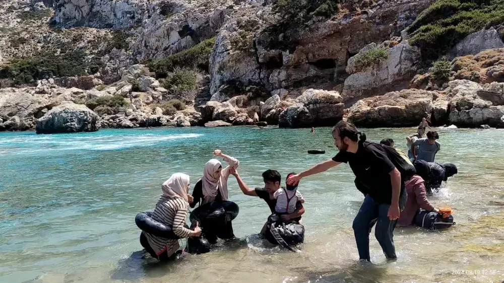 Migrants come ashore near Faros, island of Ikaria, Greece, August 19, 2024 in this still image obtained from video. Vasilis Ferraras/via REUTERS THIS IMAGE HAS BEEN SUPPLIED BY A THIRD PARTY. MANDATORY CREDIT. NO RESALES. NO ARCHIVES. TIME AND DATE STAMP FROM SOURCE