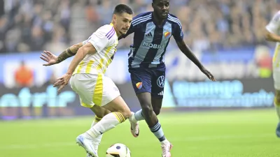 Maribor's Gregor Sikosek, left, and Djurgården's Tokmac Nguen challenge for the ball during the Conference League playoff first leg soccer match between Djurgardens IF and NK Maribor at Stockholm Arena, in Stockholm, Sweden, Thursday, Aug. 22, 2024. (Magnus Lejhall/TT News Agency via AP)