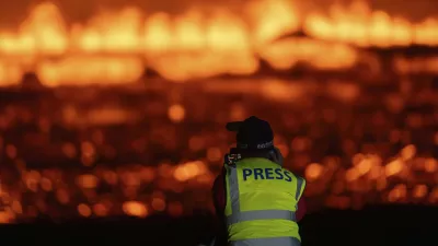 Photographers and journalists on location filming and reporting on the new fissure north of Grindavik, Iceland, Thursday, Aug. 22, 2024, (AP Photo/Marco di Marco)