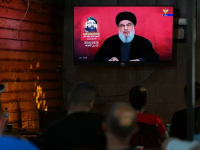 People watch Lebanon's Hezbollah leader Sayyed Hassan Nasrallah delivering a televised address, as they sit at a cafe in Beirut, Lebanon August 25, 2024. REUTERS/Mohamed Azakir