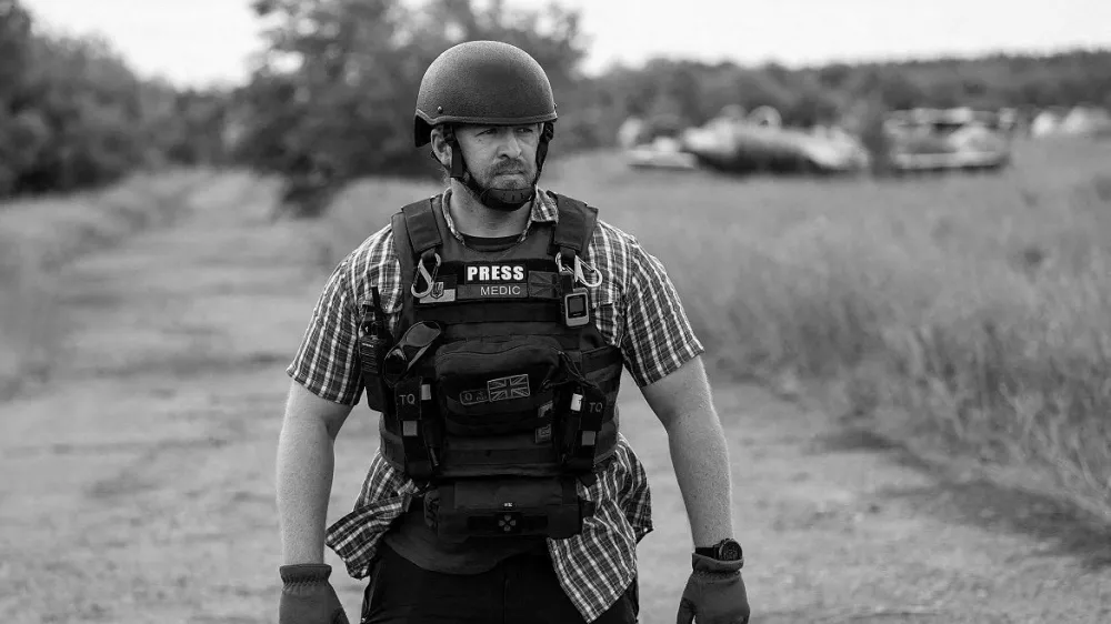 Reuters safety advisor Ryan Evans stands in a field while working with a news reporting team in an undated photo taken in Ukraine. REUTERS/Staff REFILE - QUALITY REPEAT