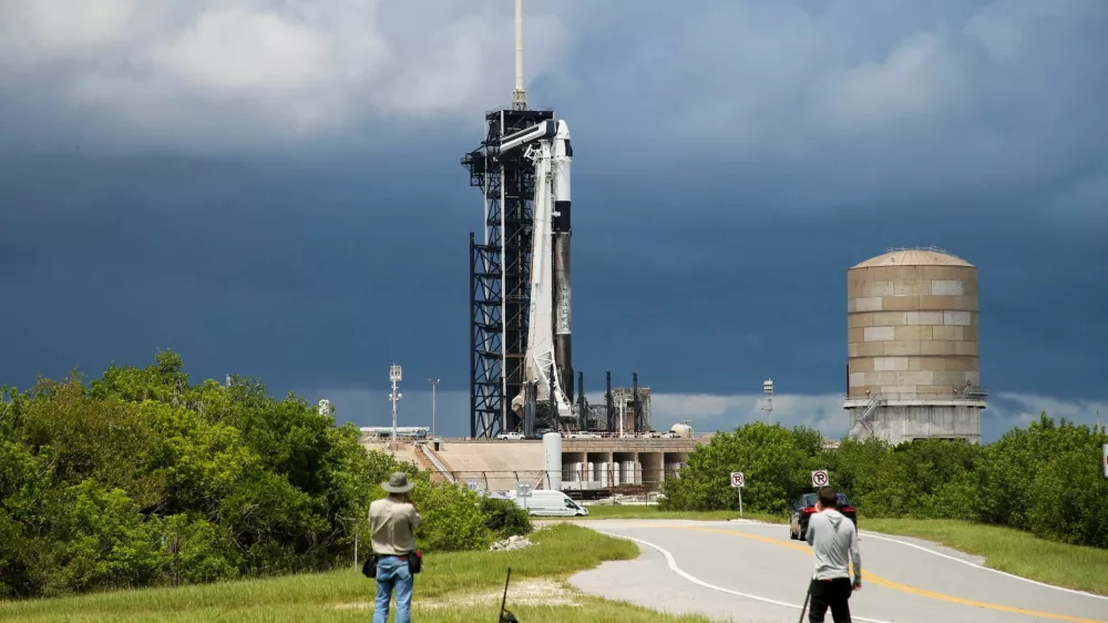 A SpaceX Falcon 9 rocket is prepared for launch of Polaris Dawn, a private human spaceflight mission, as photographers look on at the Kennedy Space Center in Cape Canaveral, Florida, U.S. August 26, 2024. Two crew members are expected to attempt the first-ever private spacewalk. REUTERS/Joe Skipper