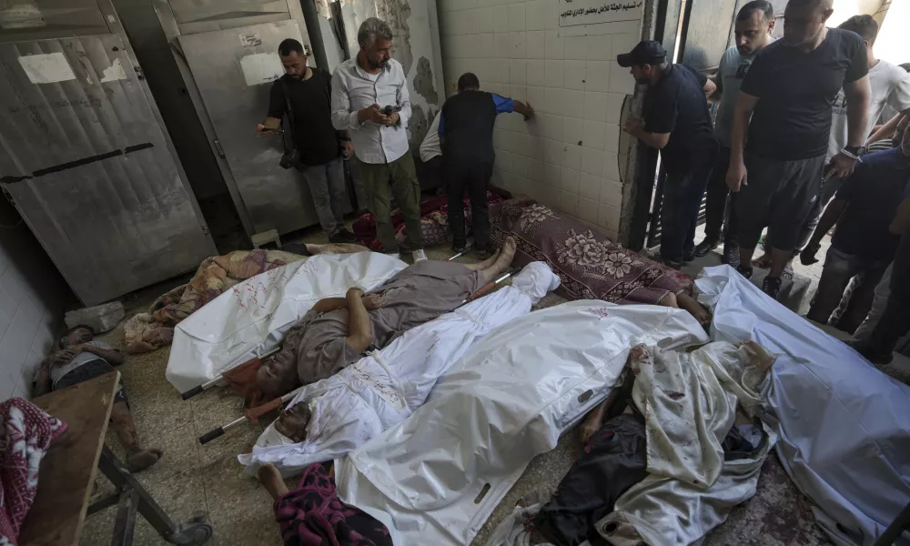 Palestinians check the bodies of their relatives killed in the Israeli bombardment of the Gaza Strip, at a hospital morgue in Deir al-Balah, Tuesday, Aug. 27, 2024. (AP Photo/Abdel Kareem Hana)