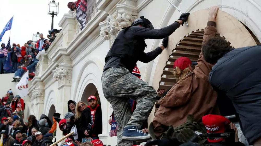 FILE PHOTO: Pro-Trump protesters scale a wall as they storm the U.S. Capitol Building, during clashes with Capitol police at a rally to contest the certification of the 2020 U.S. presidential election results by the U.S. Congress, in Washington, U.S, January 6, 2021. REUTERS/Shannon Stapleton/File Photo