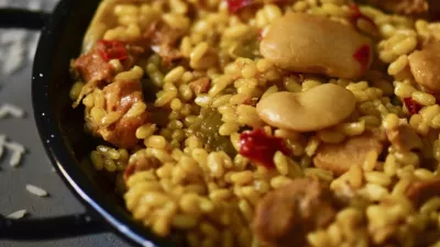 closeup of a typical spanish paella valenciana in a typical paella pan, on a gray rustic surface / Foto: Nito100