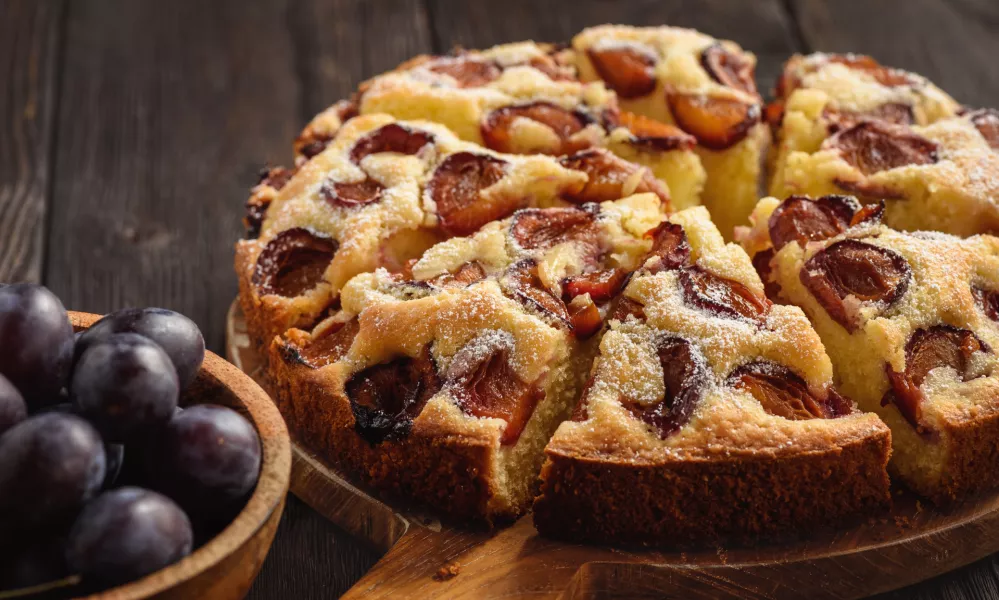 Homemade plum cake on dark wooden background. / Foto: Iko636