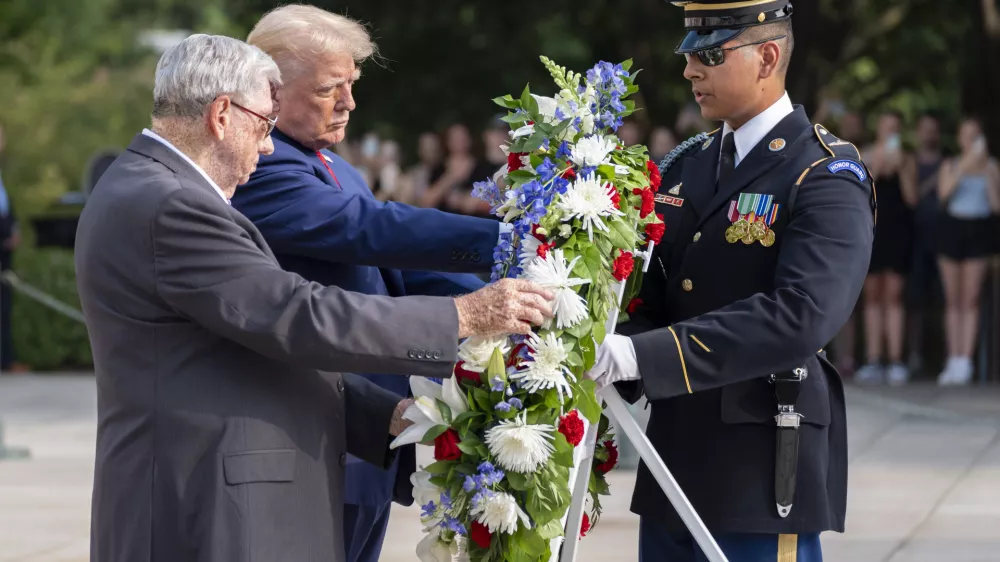 Sorodnik ubitega ameriškega vojaka in Donald Trump polagata venec na vojaškem pokopališču v Arlingtonu, kjer se je zgodil incident. Foto: AP