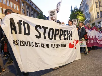 Participants in a demonstration against the right hold a banner with the slogan "Stop AfD! Racism is not an alternative" in Hamburg, Sunday, Sept. 1, 2024. (Bodo Marks/dpa via AP)