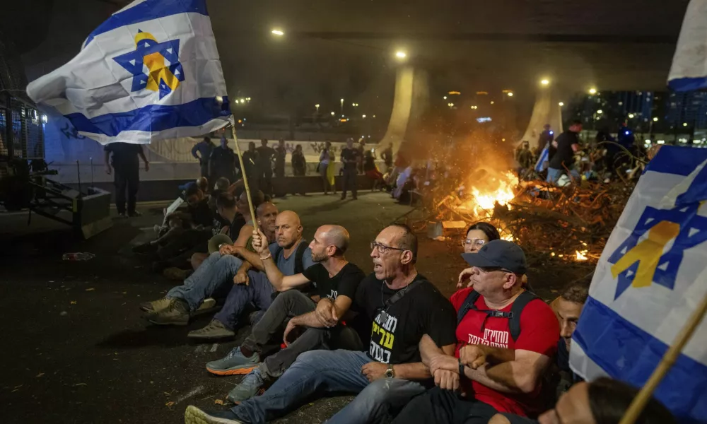 People block a road as they protest, calling for a deal for the immediate release of hostages held in the Gaza Strip by Hamas, in Tel Aviv, Israel, Sunday, Sept. 1, 2024. (AP Photo/Ohad Zwigenberg)