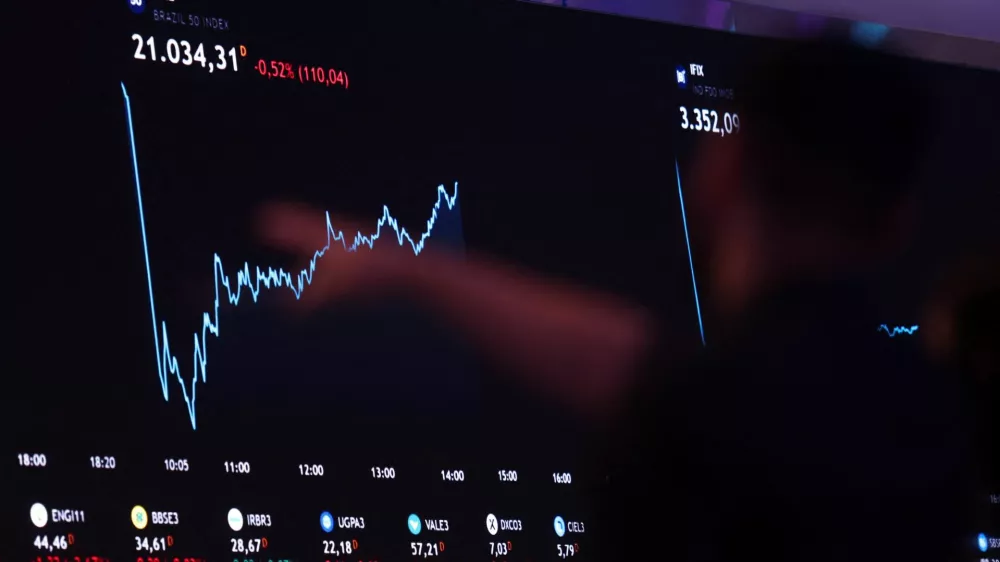 A person points to an electronic board displaying information of recent fluctuations of market indices at the B3 Stock Exchange in Sao Paulo, Brazil August 5, 2024. REUTERS/Carla Carniel