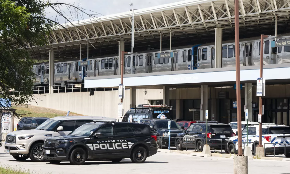 Squad cars of Elmwood Park police, Berwyn police and Cicero police are parked in the parking lot of the Forest Park Blue Line train station in Forest Park, Ill., after four people were fatally shot on the train early Monday, Sept. 2, 2024. (Pat Nabong/Chicago Sun-Times via AP)