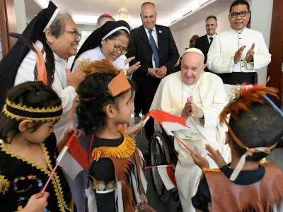 Pope Francis interacts with children as he meets with migrants, during his apostolic visit to Asia, in Jakarta, Indonesia September 3, 2024. Vatican Media/­Handout via REUTERS  ATTENTION EDITORS - THIS IMAGE WAS PROVIDED BY A THIRD PARTY.