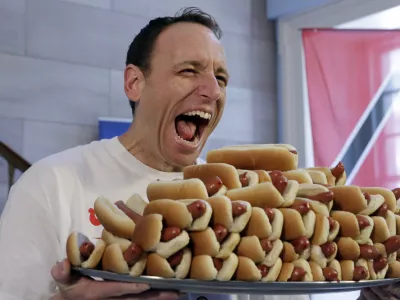 ﻿Current men's champion Joey Chestnut, of San Jose, Calif., holds a tray of hot dogs during the weigh-in for the 2017 Nathan's Hot Dog Eating Contest, in Brooklyn Borough Hall, in New York, Monday, July 3, 2017. Chestnut weighed-in at 221.5 pounds. (AP Photo/Richard Drew)