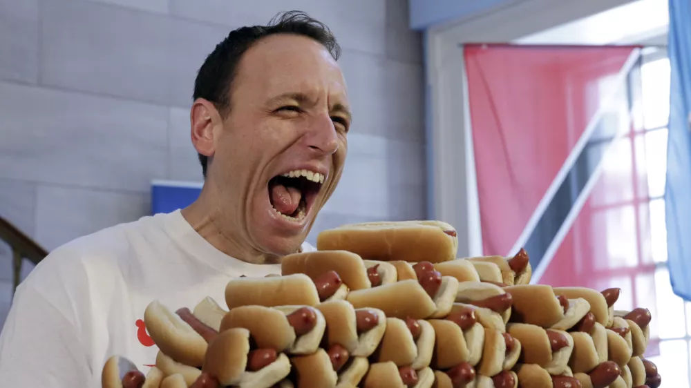 ﻿Current men's champion Joey Chestnut, of San Jose, Calif., holds a tray of hot dogs during the weigh-in for the 2017 Nathan's Hot Dog Eating Contest, in Brooklyn Borough Hall, in New York, Monday, July 3, 2017. Chestnut weighed-in at 221.5 pounds. (AP Photo/Richard Drew)