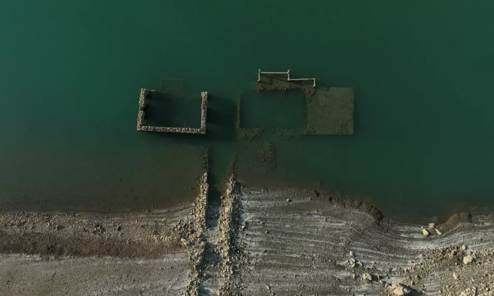 A drone view shows the reappearing remains of buildings of the village of Kallio, which was intentionally flooded in 1980 to create a reservoir that would help meet the water needs of Greek capital Athens, following receding water levels caused by drought, in Lake Mornos, Greece, September 3, 2024. REUTERS/Stelios Misinas