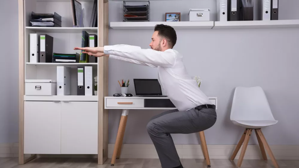 Portrait Of A Happy Young Businessman Doing Workout In Office / Foto: Andreypopov