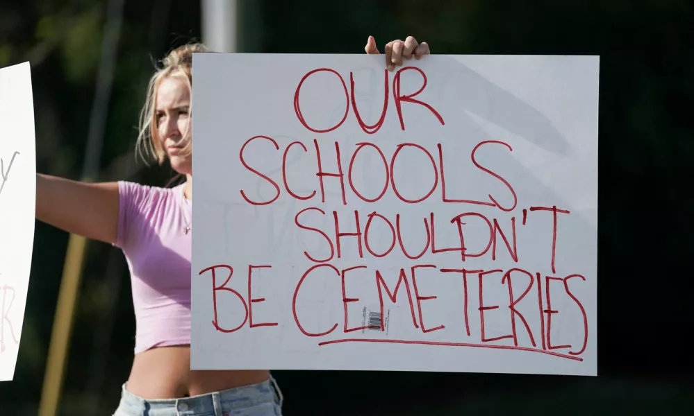 Student Gretchen Gierlach, 18, holds up signs following a shooting at Apalachee High School in Winder, Georgia, U.S. September 4, 2024. REUTERS/Elijah Nouvelage