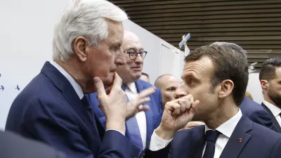 FILE - French President Emmanuel Macron, right, whispers to European Union chief Brexit negotiator Michel Barnier as he visits the International Agriculture Fair, in Paris, France. President Emmanuel Macron named the former EU Brexit negotiator as France's new prime minister on Thursday after more than 50 days of caretaker government. (AP Photo/Michel Euler, File)