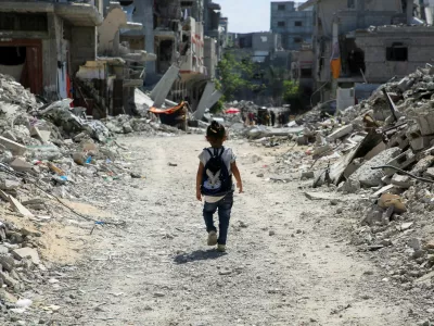 A Palestinian student walks between the rubble after attending a class in a tent set up on the rubble of the house of teacher Israa Abu Mustafa, as war disrupts a new school year, amid the Israel-Hamas conflict, in Khan Younis, in the southern Gaza Strip, September 4, 2024. REUTERS/Hatem Khaled