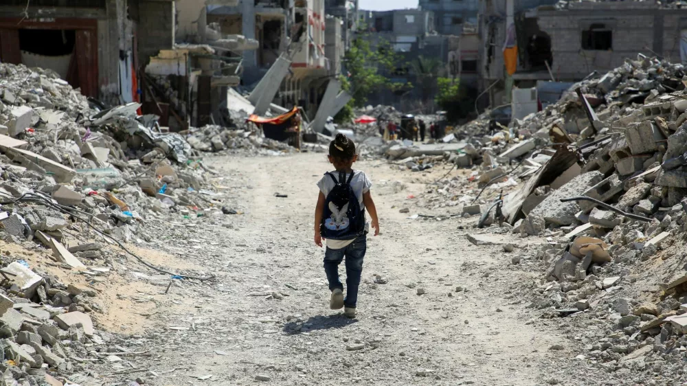 A Palestinian student walks between the rubble after attending a class in a tent set up on the rubble of the house of teacher Israa Abu Mustafa, as war disrupts a new school year, amid the Israel-Hamas conflict, in Khan Younis, in the southern Gaza Strip, September 4, 2024. REUTERS/Hatem Khaled