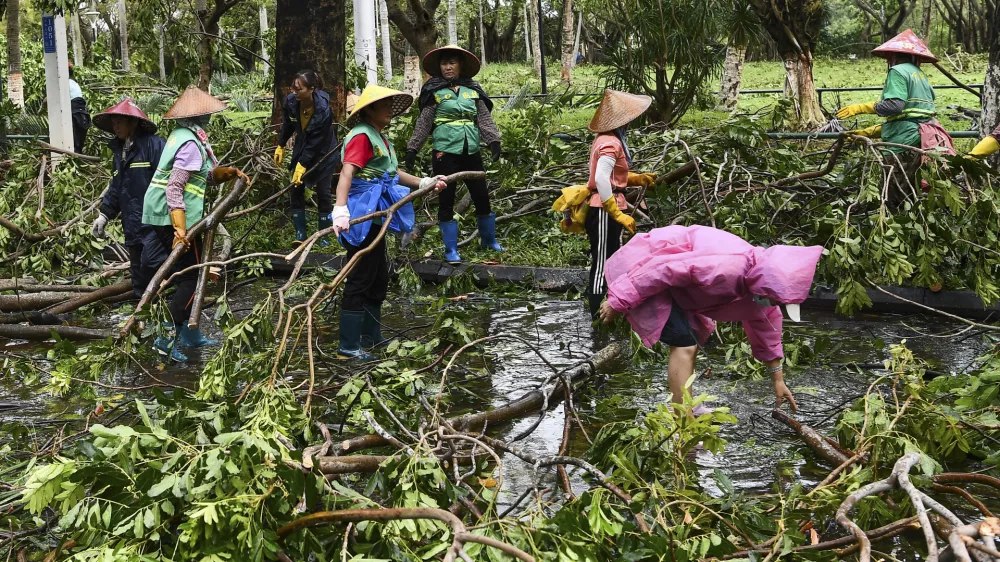 In this photo released by Xinhua News Agency, workers remove fallen tree branches along a street in the aftermath of Typhoon Yagi in Haikou, south China's Hainan Province, Saturday, Sept. 7, 2024. (Yang Guanyu/Xinhua via AP)