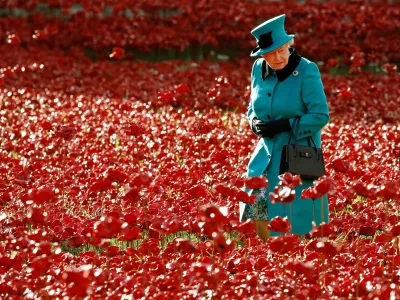 FILE PHOTO: Britain's Queen Elizabeth walks through a field of ceramic poppies that form part of the art installation "Blood Swept Lands and Seas of Red", at the Tower of London in London October 16, 2014. REUTERS/Luke MacGregor/File Photo