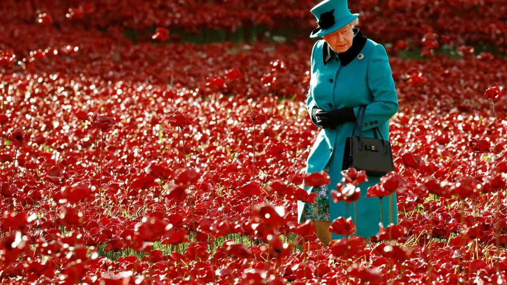 FILE PHOTO: Britain's Queen Elizabeth walks through a field of ceramic poppies that form part of the art installation "Blood Swept Lands and Seas of Red", at the Tower of London in London October 16, 2014. REUTERS/Luke MacGregor/File Photo