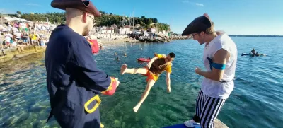 Dijaki višjih letnikov so svoje mlajše kolege drugega za drugim pometali v morje. Foto: Vesna Levičnik