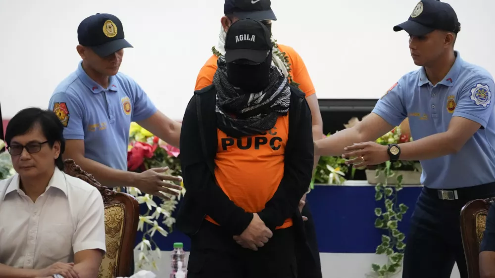 Apollo Quiboloy, center, a Filipino preacher accused of sexual abuse and human trafficking in the Philippines and similar charges in the United States, is escorted beside Philippine Secretary of Interior and Local Government Benhur Abalos, left, during a press conference at the Camp Crame police headquarters in Quezon City, Philippines Monday, Sept. 9, 2024. (AP Photo/Aaron Favila)