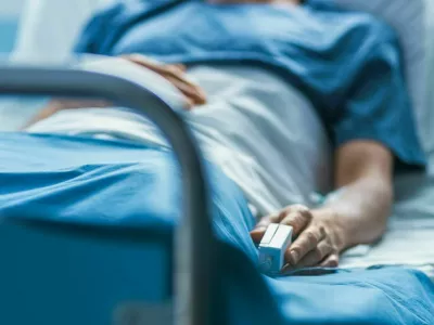 In the Hospital Sick Male Patient Sleeps on the Bed. Heart Rate Monitor Equipment is on His Finger. / Foto: Gorodenkoff