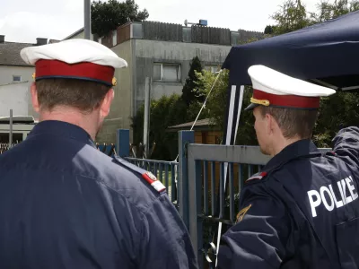 Two policemen are seen at the backyard entrance of a house that was the scene of a crime of incest and abuse in Amstetten, Lower Austria, Saturday, May 3, 2008 as the gathering of evidence continues. A man allegedly held his daughter captive in a dungeon of his house for 24 years, abusing her and fathering her seven children. Authorities investigating the Austrian man accused of imprisoning and raping his daughter are awaiting old court records that media say document a 1967 rape allegation. Lower Austria prosecutor Gerhard Sedlacek told The Associated Press Saturday that he did not yet know the contents of the file. He refused to confirm reports that Fritzl had a previous record for a sexual crime. (AP Photo/Kerstin Joensson)