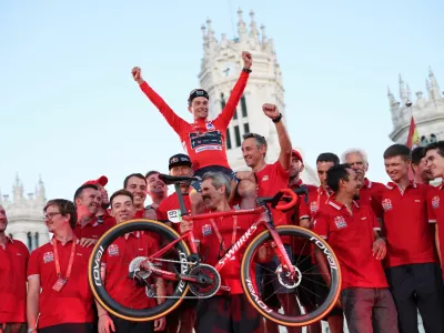 Cycling - Vuelta a Espana - Stage 21 - Madrid to Madrid - Spain - September 8, 2024 Red Bull - Bora - Hansgrohe's Primoz Roglic celebrates with his team and bike after winning the Vuelta a Espana REUTERS/Isabel Infantes