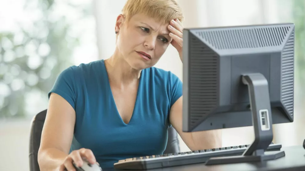 Tensed mature businesswoman using computer at desk in office / Foto: Tetmc