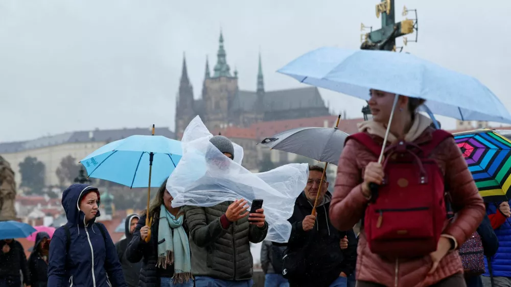 People walk across the medieval Charles Bridge during a rainstorm in Prague, Czech Republic, September 13, 2024. REUTERS/David W Cerny