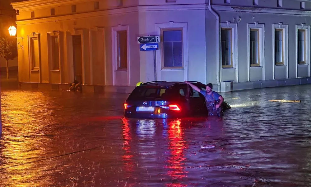 14 September 2024, Austria, Zwettl: A man leans on a car submerged in flood water. Due to heavy rainfall, the whole of Lower Austria was declared a disaster area on 15 September. Photo: Doku-Nö/APA/dpa